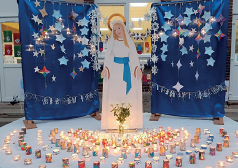Une statue de la vierge devant des lampions